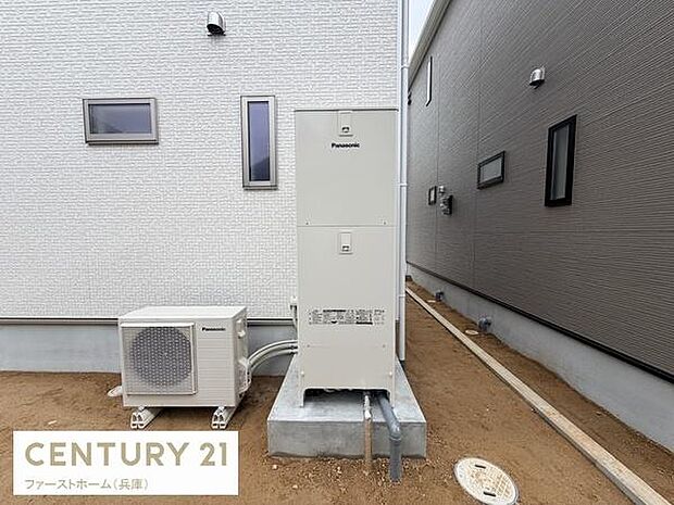 屋外スペースに設置された給湯器とエアコンの室外機が並んでいます。建物同士の間隔が確保されているため作業や点検も行いやすい配置です。シンプルな設備で使いやすさが感じられます。