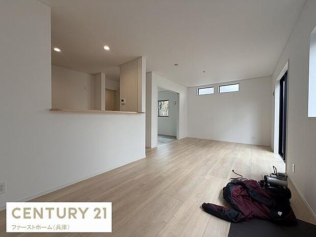 リビングは大きな窓から自然光が入る明るい空間です。シンプルな内装が印象的でレイアウトの自由度があります。床材の色味がやさしく落ち着いた印象です。天井のダウンライトが部屋全体を照らします。