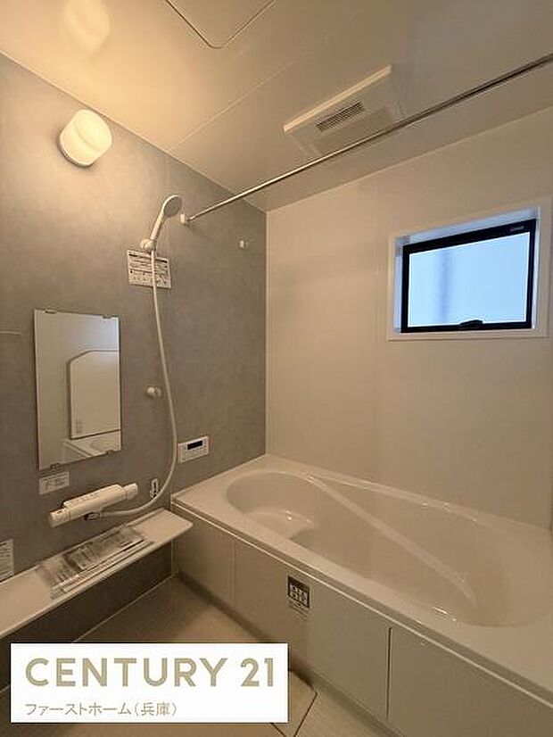 明るいライトが設置されており浴室全体をしっかり照らします。便利なワイドミラーが備え付けられ使い勝手の良い空間です。小窓もあり換気や採光に配慮されています。収納棚も備えており小物整理に便利です。