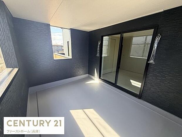 開放感のあるバルコニーは広々とした設計です。大きな窓からしっかりと光が差し込みます。ブラックの壁面が落ち着いた印象を与えます。室内からのアクセスも便利です。天候を気にせず使いやすい空間です。