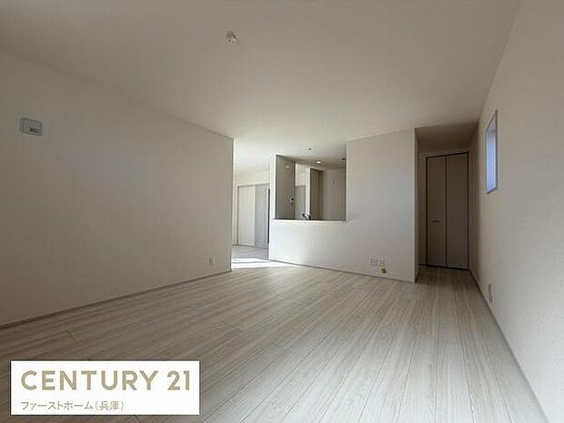 リビングは白を基調とした内装で部屋全体が明るく感じられます。開放感のある空間設計が魅力です。床材はナチュラルな色合いでシンプルな雰囲気を演出しています。