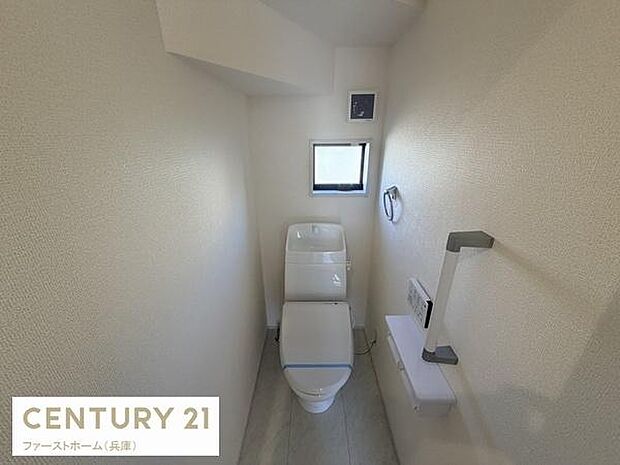 シンプルな内装で清潔感のあるトイレです。小窓から自然光が入り明るく感じられます。手すりやペーパーホルダーなど設備も充実しています。スペースが使いやすい設計です。