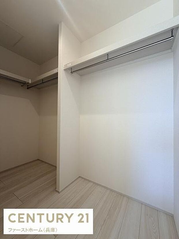 広々とした収納スペースが確保されています。ハンガーパイプ付きで整理がしやすい仕様です。床と壁の色合いがすっきりとした印象を与えます。クローゼット内が明るく開放的に感じられます。