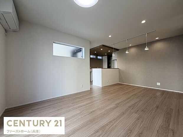 落ち着いた色合いのフローリングが室内に調和した雰囲気を与えます。開放感のある広々としたリビング空間です。ダウンライトやペンダントライトがアクセントとなっています。