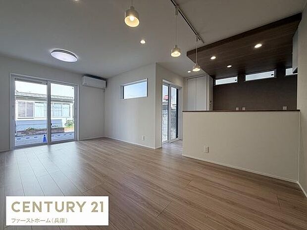 開放感のある広々としたリビングです。大きな窓からたっぷり自然光が差し込みます。木目調の床が落ち着いた雰囲気を演出しています。ダウンライトとペンダントライトが空間を照らし明るい印象です。