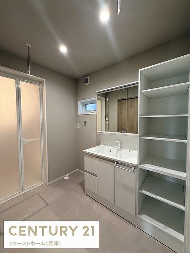 洗面所は清潔感のあるデザインで広々としたスペースが確保されています。大きな鏡と収納棚が備わっており日々の使用にも便利です。すっきりとした直線的なフォルムが空間を引き立てています。