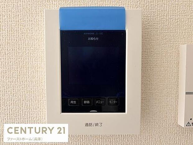 シンプルなデザインのモニター付きインターホンが設置されています。液晶画面で来客を確認できます。エントランスの安心感があります。ボタン操作もわかりやすい仕様です。壁際にすっきり収まっています。