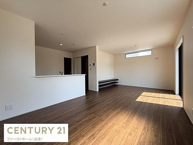 リビングは広々とした空間でナチュラルな木目調のフローリングが特徴です。窓から光が差し込み明るさを感じられる設計です。キッチンとのつながりも良く開放感があります。