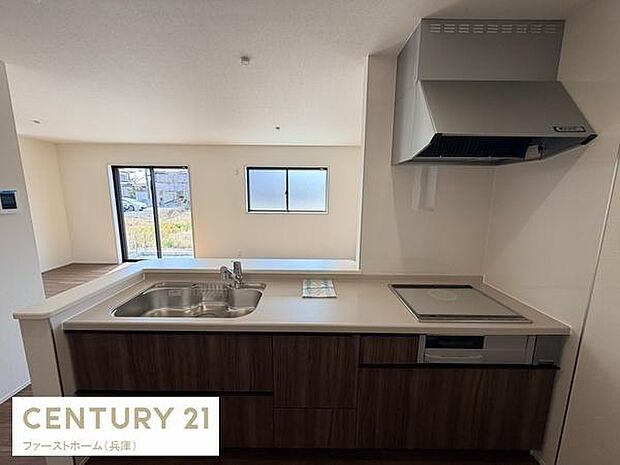 リビングに面したカウンターキッチンが魅力的な空間です。明るい日差しが差し込む大きな窓があり開放感があります。室内はシンプルで使いやすいデザインです。収納スペースも豊富に設計されています。