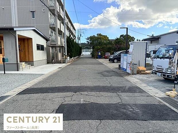 前面道路がまっすぐに広がっており周辺の建物や車両もきれいに整備されています。敷地前の舗装もしっかりしているので安心してご利用いただけます。周囲には住宅や施設が並び落ち着いた雰囲気が感じられます。