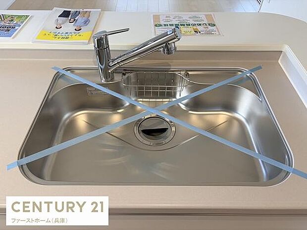 ステンレス製のシンクが清潔感を与えます。蛇口も使いやすい位置に設置されています。カウンターのスペースも広く作業が快適に進みます。全体的にすっきりとしたデザインが印象的です。