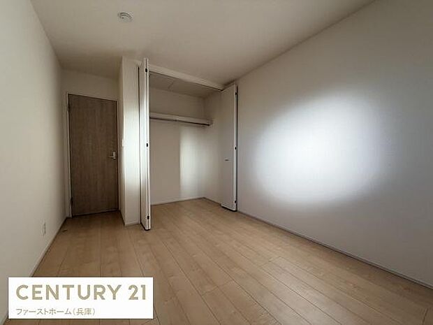 明るい木目調のフローリングが目を引く子供部屋です。シンプルな内装でインテリアのアレンジが楽しめます。クローゼット付きで収納に便利です。白い壁が空間を広く感じさせます。木製ドアが温かみを添えています。