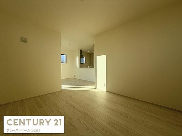 ナチュラルな色合いのフローリングが空間を明るく演出しています。壁や天井のシンプルなデザインが特徴です。窓から差し込む自然光が室内を開放的にしています。ゆったりとした広さを感じさせるリビングです。