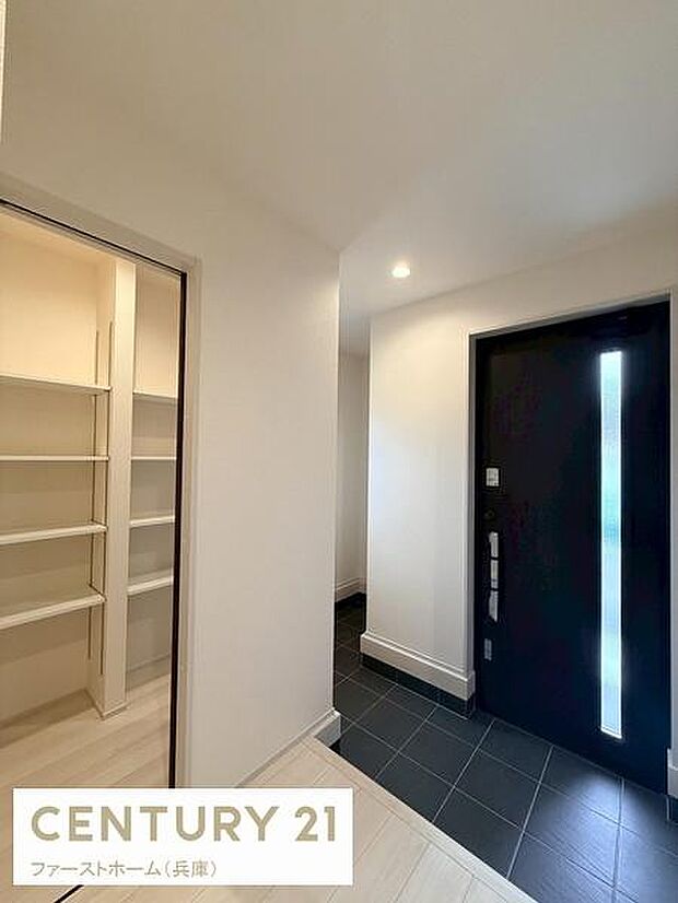 玄関は広々とした空間があり落ち着いた雰囲気が感じられます。大きな扉が印象的で収納スペースも充実しています。照明が明るさを確保しており清潔感のある空間となっています。使いやすさが考えられた設計です。