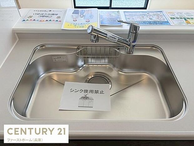 ステンレス製のシンクが設置されておりお手入れがしやすいデザインです。作業スペースも確保されているので調理や片付けもスムーズに行えます。収納や整理に便利な小型ラックも付いています。