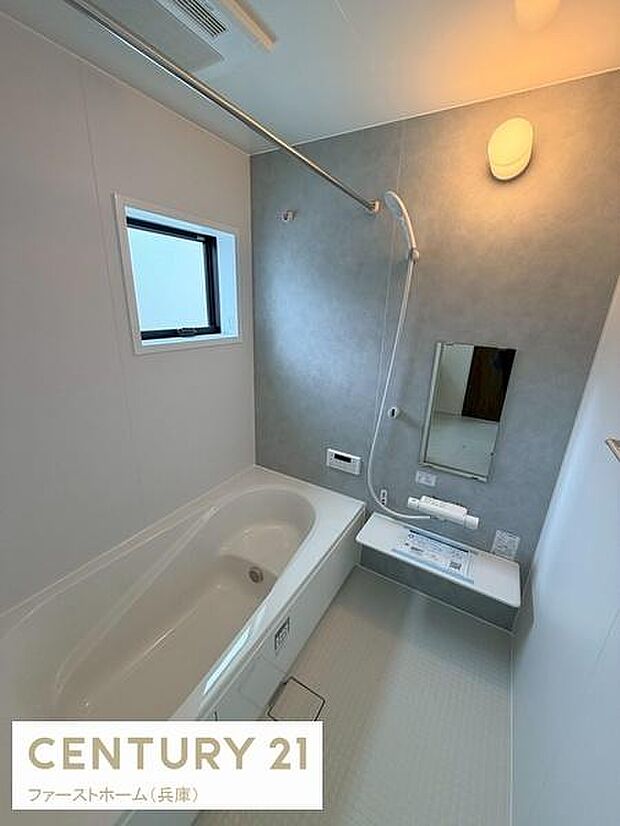 清潔感のあるシンプルなバスルームです。浴槽はゆったりとしたサイズ感となっています。壁面は落ち着いた色合いで照明も明るさを感じられます。窓付きで換気もしやすい設計です。使いやすさに配慮された空間です。