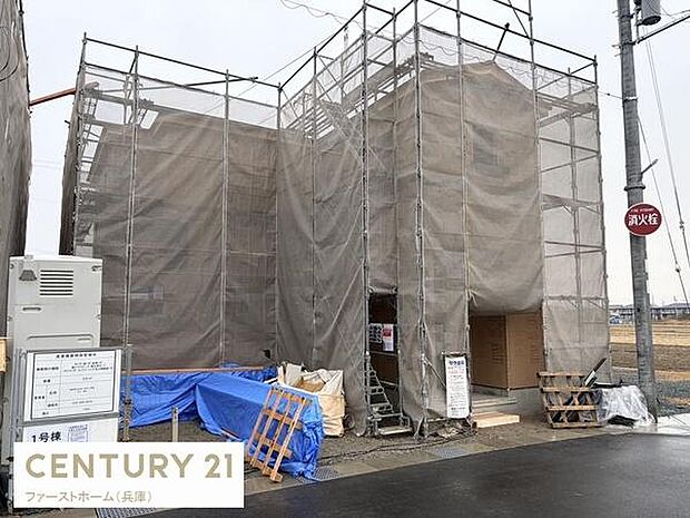 建築中の住宅で完成が楽しみな物件です。足場や養生シートが丁寧に設置されています。新築ならではの雰囲気が伝わります。現地の様子がしっかり分かる写真です。前面道路からのアクセスも確認できます。