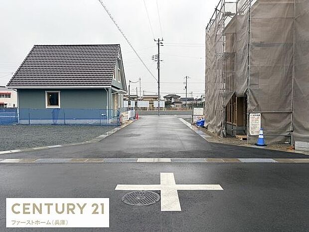 前面道路がしっかり舗装されており歩道や車の出入りがスムーズに行えます。周辺には新しい建物も見受けられ清潔感があります。現地の様子がひと目でわかる写真です。周囲が開けているため開放感を感じられます。