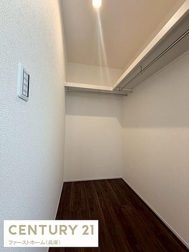 シンプルなデザインが印象的な玄関です。白を基調とした壁とダークなフローリングが調和しています。照明付きで明るさも確保されています。収納スペースもありすっきりとした印象の玄関です。