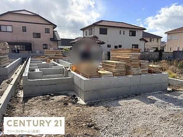 基礎工事がしっかりと進行している様子がうかがえます。敷地内は整然と資材が配置されています。周囲は落ち着いた住宅街となっています。青空のもとでの建築が進行しています。