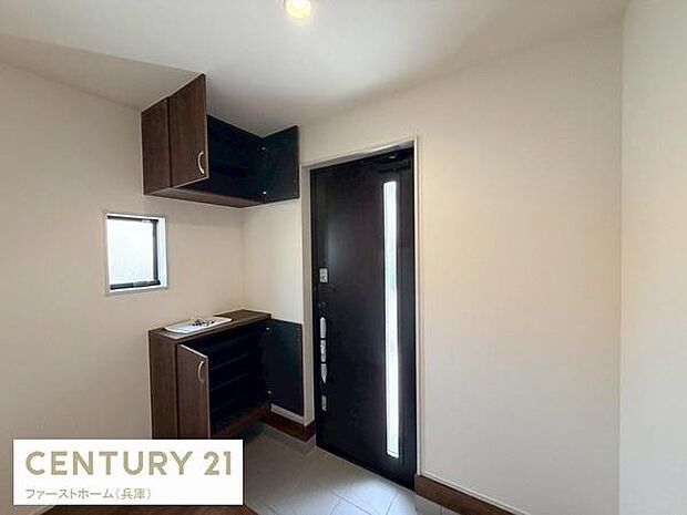 玄関はシンプルで使いやすい空間です。収納スペースが備え付けられており整理整頓に役立ちます。採光窓があり明るさも確保されています。ブラックのドアがアクセントとなっています。スッキリとした印象の玄関です。