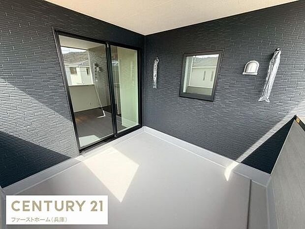 ゆったりとした空間が広がるバルコニーは複数の用途に活用しやすい設計です。大きな窓から自然光が差し込み明るさが感じられます。壁や床面のシンプルなデザインが現代的な印象を与えています。