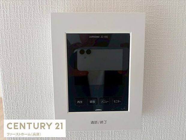 シンプルなデザインのインターホンが設置されています。操作ボタンも視認性が高く使いやすい配置です。室内の雰囲気に馴染むホワイトフレーム仕様。壁の質感も感じられる配置となっています。