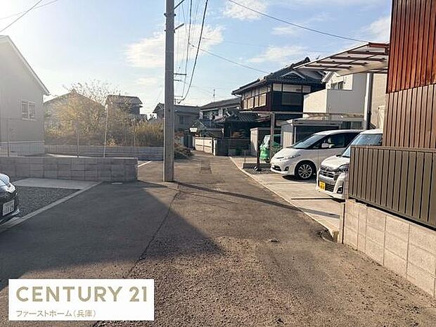 周辺は落ち着いた住宅街で交通量も少なめの前面道路が特徴です。道路幅も十分で車の出し入れもしやすそうです。陽当たりも良好で明るい雰囲気の現地写真となっています。駐車スペースも確認できます。