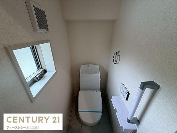 明るい光が差し込む窓があり換気にも便利なトイレです。シンプルな内装で清潔感を感じられます。ペーパーホルダーや手すりも設置されていて使いやすさに配慮されています。