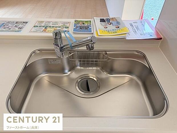 広々としたシンクが特徴のキッチンです。水栓は使いやすく日々の家事が快適に進みます。ステンレス仕上げで清潔に保ちやすいです。シンプルなデザインが魅力の一つです。カウンターとの一体感も感じられます。