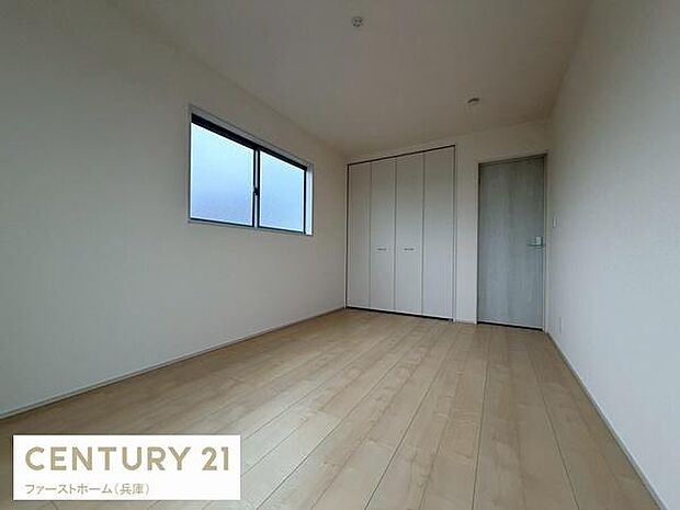 白を基調とした壁と明るいフローリングが調和した洋室です。大型クローゼットや大きな窓が配置され空間に開放感を演出しています。シンプルな内装で多様なインテリアにも合わせやすい仕上がりです。