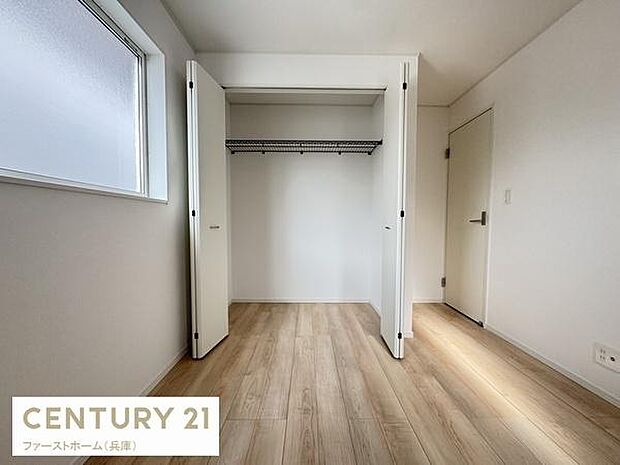 ナチュラルなフローリングが明るい印象を与える洋室です。大きなクローゼットが備わっており収納に便利です。二面採光の窓が室内にしっかりと光を取り込んでいます。