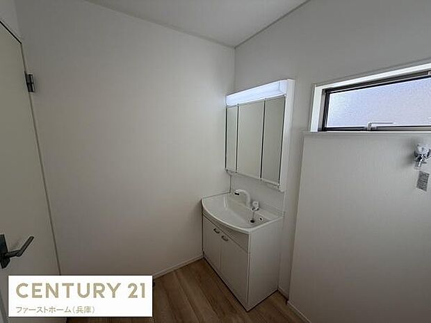 洗面スペースがすっきりとまとめられています。窓が設けられているため明るさを感じられます。収納付きの洗面台で快適に使えます。木目調の床が清潔感を引き立てます。