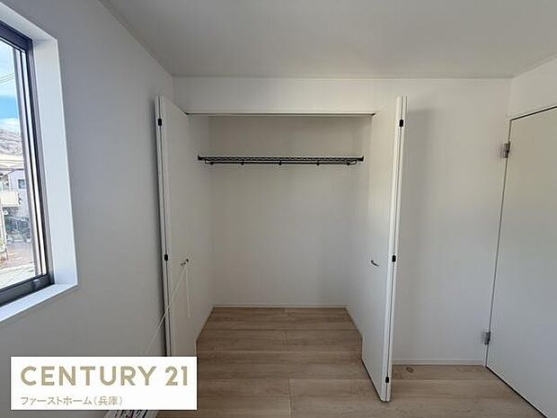 クローゼットは幅のある開口で使い勝手の良い空間が広がっています。ナチュラルな床材と白い壁で室内がすっきりと見えます。窓からの採光もあり収納スペースが明るい印象です。衣類や日用品の整理整頓に役立ちます。