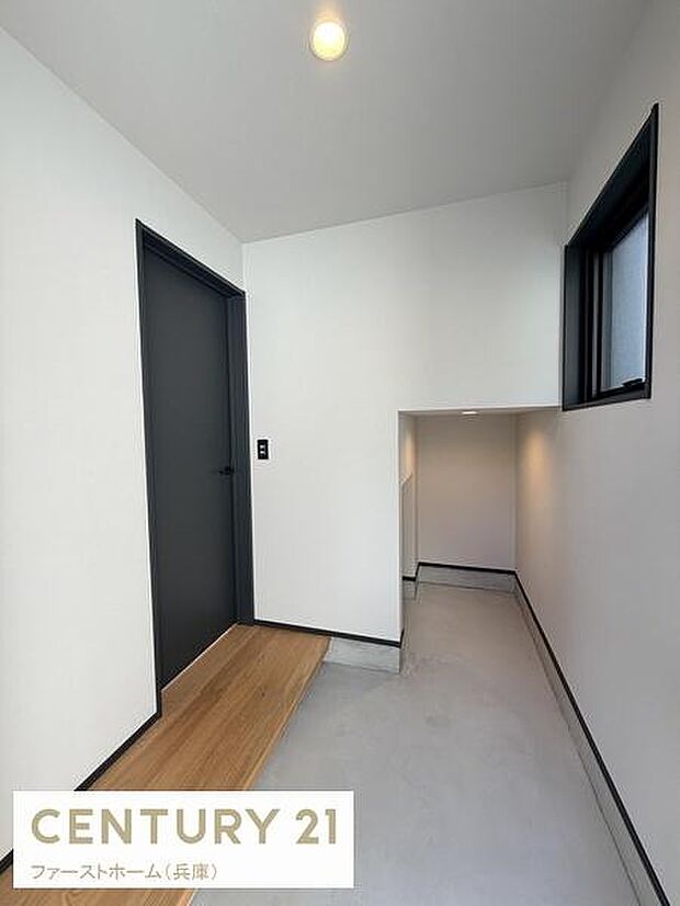 シンプルなデザインが際立つ玄関です。明るい照明と窓からの光が空間に開放感をもたらします。収納スペースの配置も工夫されています。落ち着いた色合いの扉が印象的です。清潔感のある床材が魅力です。