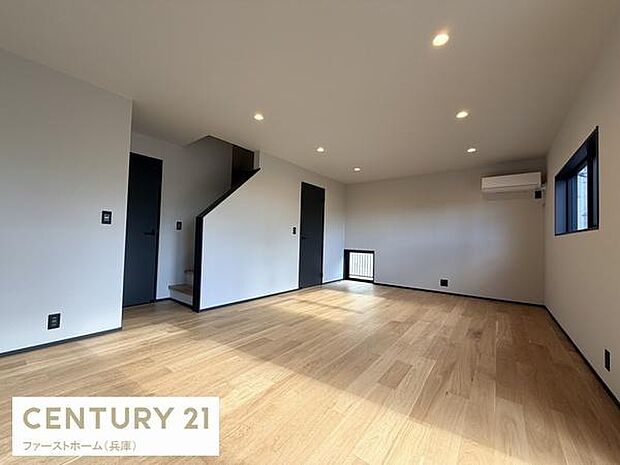 明るさを感じるリビングが広がっています。シンプルな内装でさまざまなインテリアと調和しやすい空間です。大きな窓とダウンライトが室内をすっきりと見せています。木目調の床が温かみを与えます。