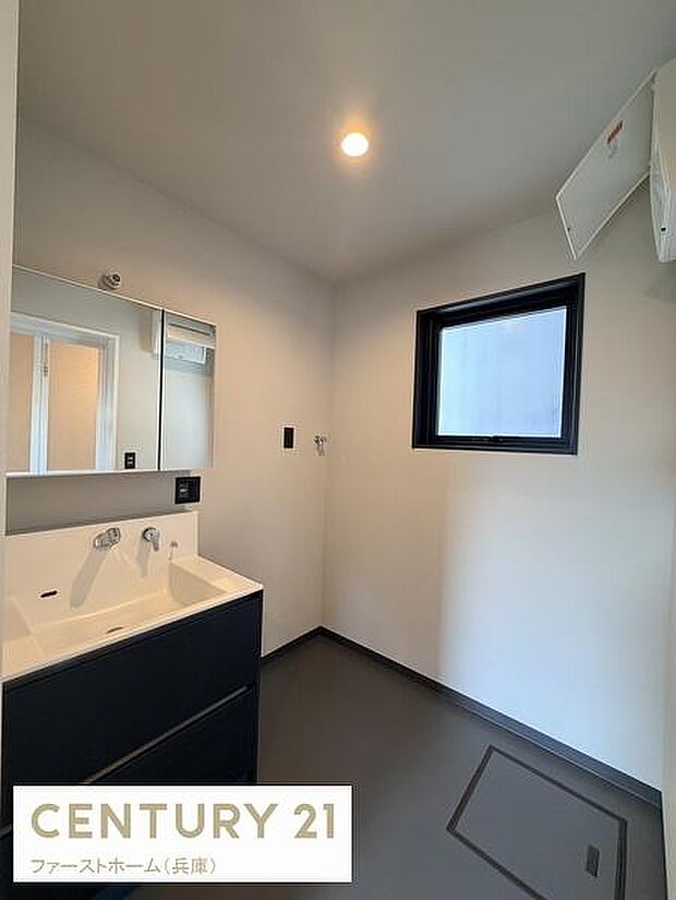 洗面台はシンプルなデザインで清潔感のある空間です。大きな鏡が使いやすさを高めています。窓が設けられており自然光を取り入れることができます。収納も備えているため日常の使い勝手にも配慮されています。