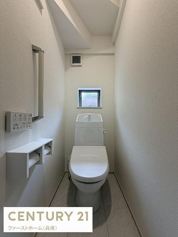 小窓付きで換気がしやすいトイレです。壁にペーパーホルダーと手すりが設置されており使いやすさが考えられています。シンプルなデザインで清潔感のある空間です。ゆとりのある設計が特徴です。