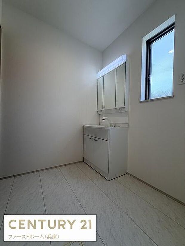 明るい光が差し込む洗面所です。シンプルな洗面台がすっきりとした印象を与えます。窓付きで換気にも配慮された空間です。収納スペースも備えています。