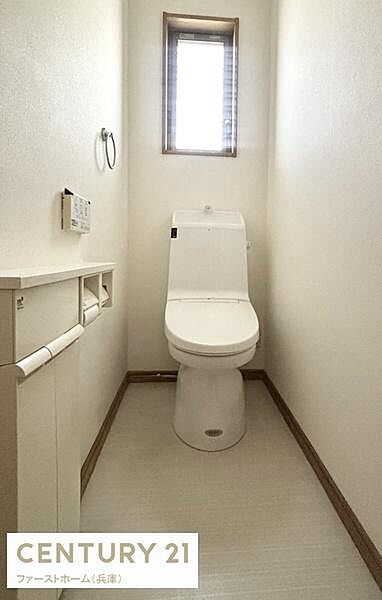 窓付きで換気しやすいトイレです。清潔感のある内装が印象的です。ペーパーホルダーやリモコンも手元に配置されています。シンプルなデザインで空間がすっきりしています。