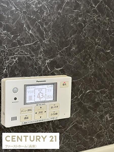 落ち着いた雰囲気の石目調パネルに見やすいパネル式の給湯リモコンが設置されています。シンプルな操作ボタンで使い勝手が良い印象です。温度表示も大きく手元で簡単に調整できます。浴室空間に調和した設備です。