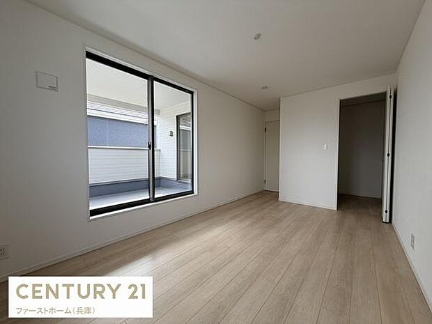 大きな窓から明るい光が差し込む寝室です。シンプルな内装で家具の配置も自由自在です。クローゼットスペースも備えています。バルコニーへのアクセスもスムーズです。清潔感のあるフローリングが魅力です。