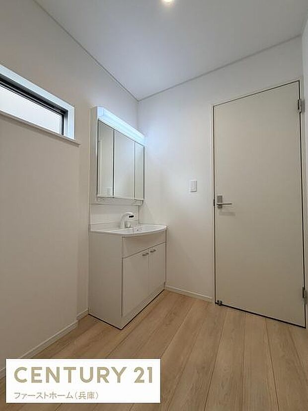 洗面台・洗面所はシンプルで清潔感のある空間です。壁面のミラーが広々とした印象を与えます。明るい床材と白を基調としたデザインが特徴的です。窓からの自然光も心地よく感じられます。収納も備わっています。