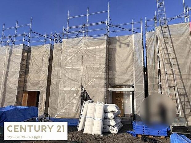 建築中の外観がしっかりと確認できます。資材が整然と配置されており工事の進捗が伝わります。足場が組まれているため今後の完成イメージが楽しみです。青空の下で撮影され現場の状況が分かりやすいです。