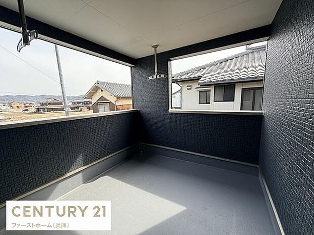 日当たりが良く開放感のあるバルコニーです。周囲の景色も広がりを感じられる空間になっています。壁面のデザインがシンプルで清潔感があります。屋根付きなので天候の影響も受けにくい仕様です。