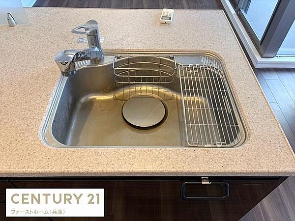広々としたシンクが特徴のキッチンです。使い勝手の良い水栓と付属の水切りラックが設置されています。全体的に清潔感のあるデザインでお手入れも簡単です。周囲もすっきりとした印象です。