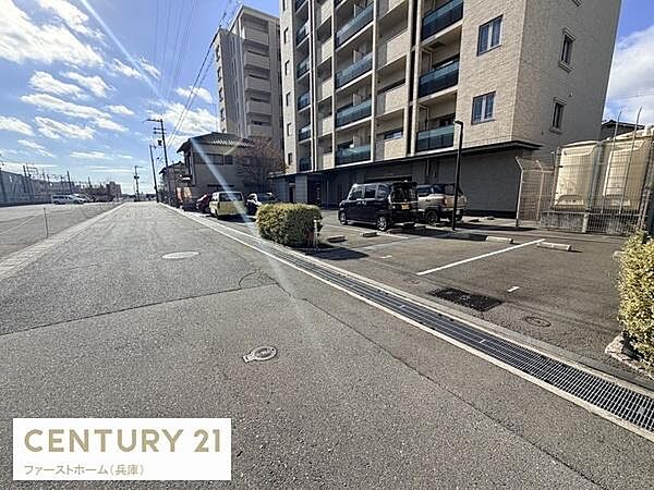 マンション敷地内に設けられた駐車場です。広々としたスペースで車両の出し入れもスムーズに行えます。敷地周辺も見通しが良く安心してご利用いただけます。平坦な舗装面が特徴的です。