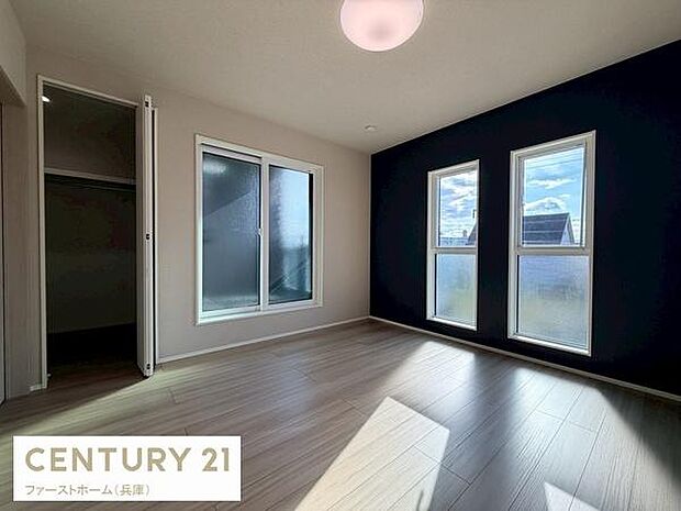 シンプルで洗練された内装が特徴の寝室です。二面採光で明るい雰囲気が広がります。すっきりとしたフローリングが空間を引き立てます。収納スペースも備えています。アクセントクロスが印象的です。