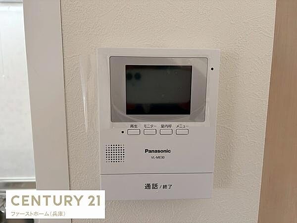 壁に設置されたパナソニック製のモニター付きインターホンが見られます。来客時の確認が手軽にできます。使いやすいボタン配置も特徴的です。室内の設備がしっかり整っています。操作もシンプルで直感的に使えます。