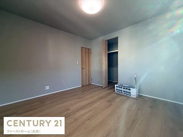 シンプルな内装が特徴の寝室です。クローゼット付きで収納もしっかり確保されています。木目調のフローリングが落ち着いた雰囲気を演出しています。照明も設置されており明るさも十分です。